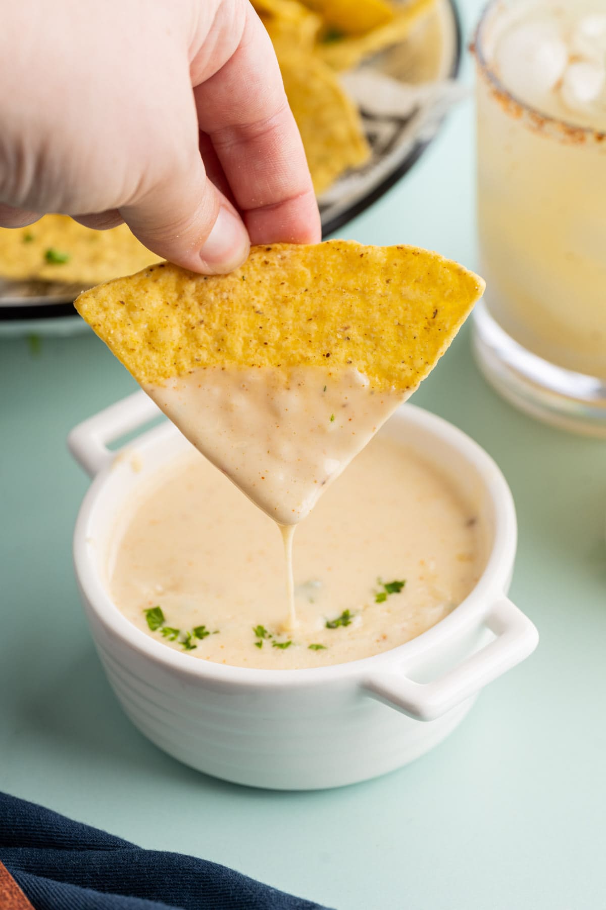 Tex-Mes queso blanco dripping off a tortilla chip