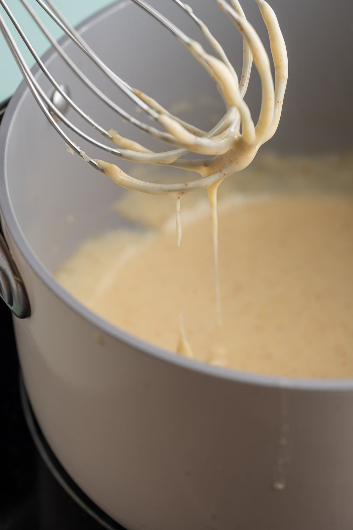 Tex-Mex Queso Blanco dripping off a whisk