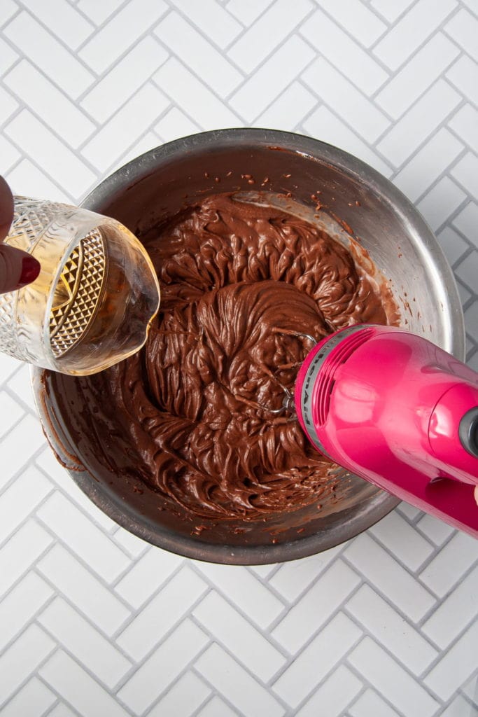 adding brandy to chocolate mousse with hand mixer on