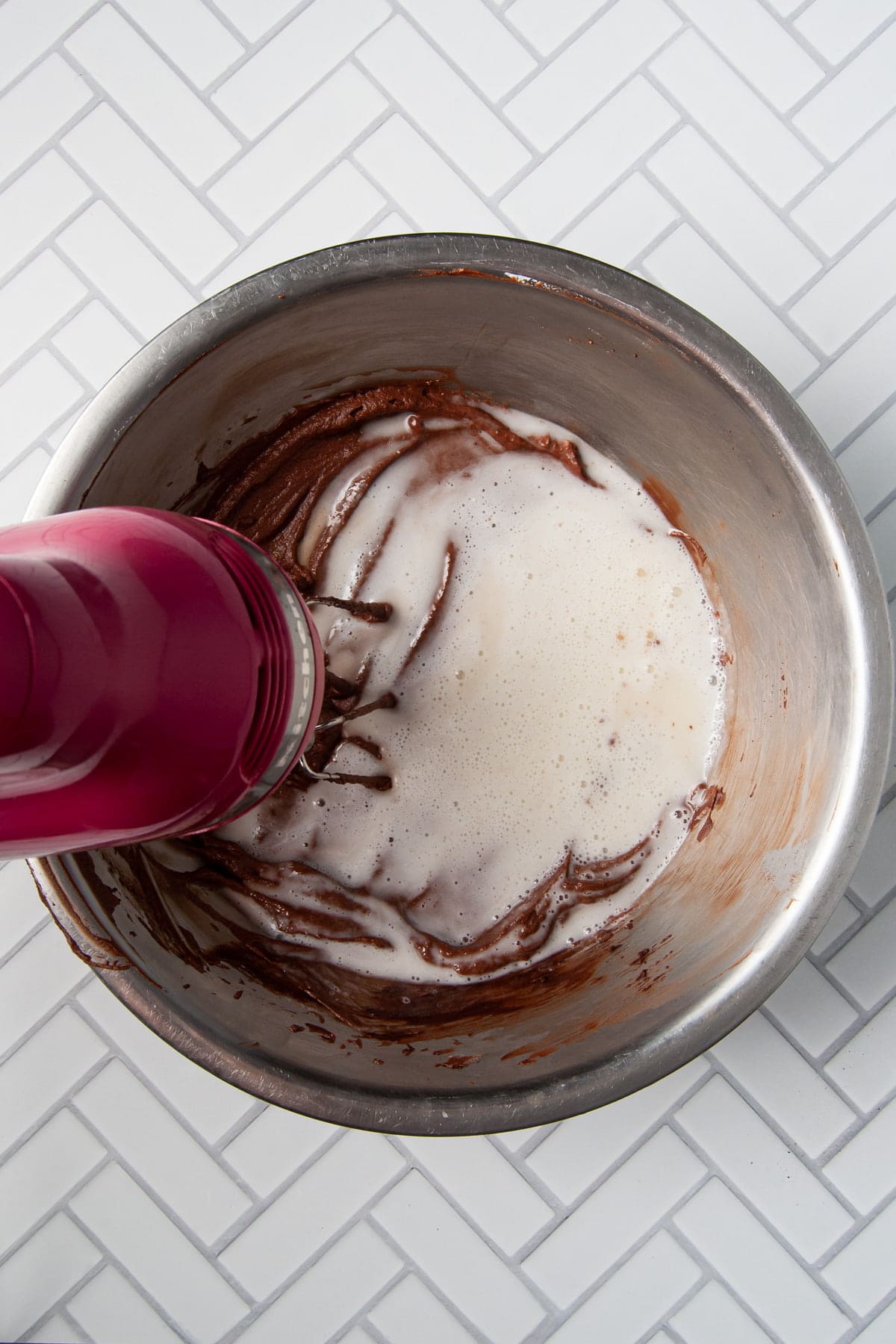 adding egg white and sugar mixture to chocolate mousse