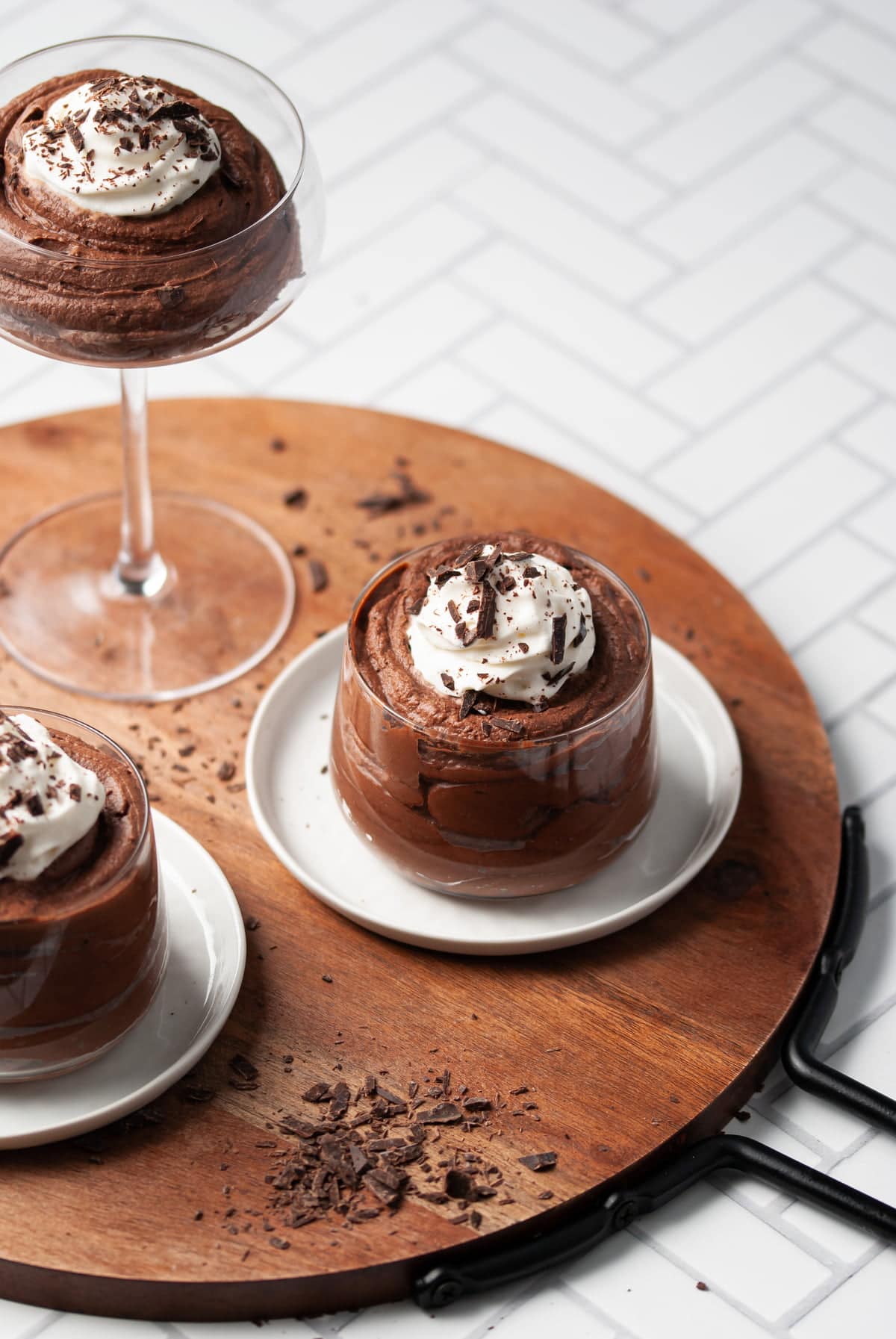 three glasses of boozy chocolate mousse on a wooden board