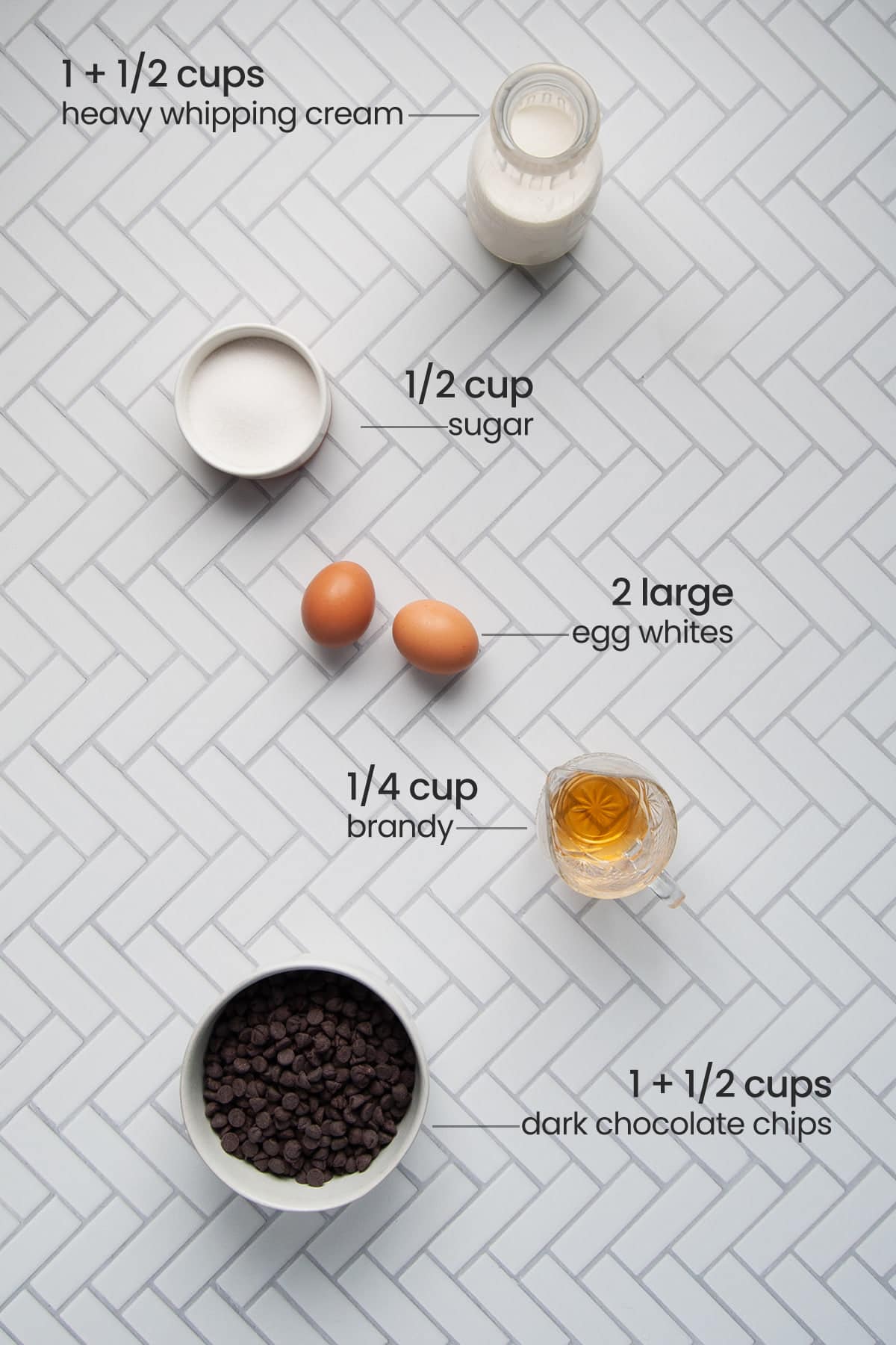ingredients for boozy chocolate mousse - heavy whipping cream, sugar, egg whites, brandy, dark chocolate chips