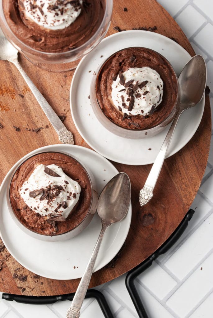 overhead shot of 3 glasses of boozy chocolate mousse topped with whipped cream