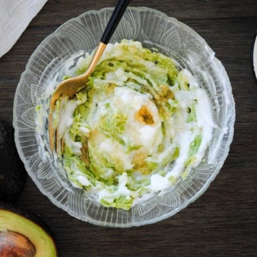 mixing together mashed avocado, honey, and coconut oil hair mask in a bowl