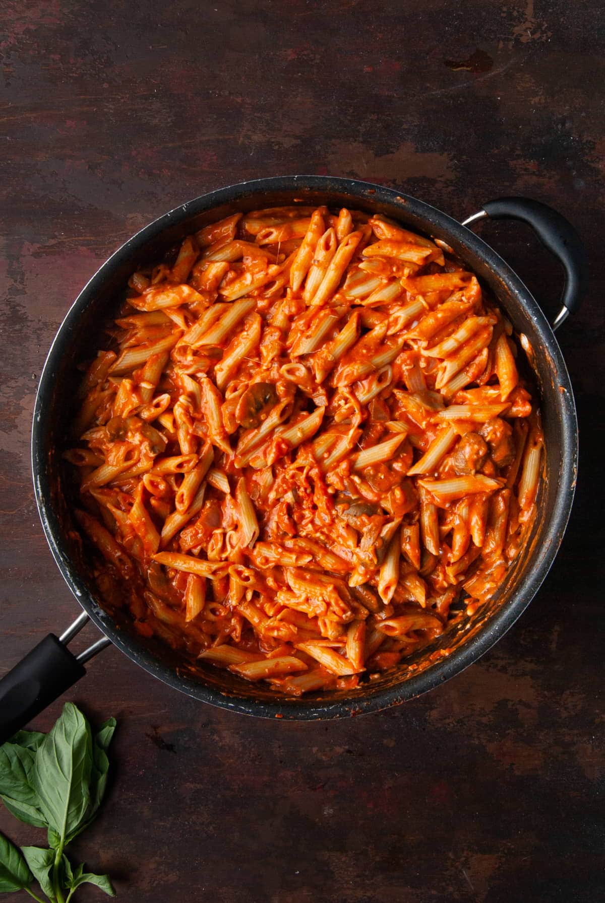 penne pasta covered in sauce in the pan