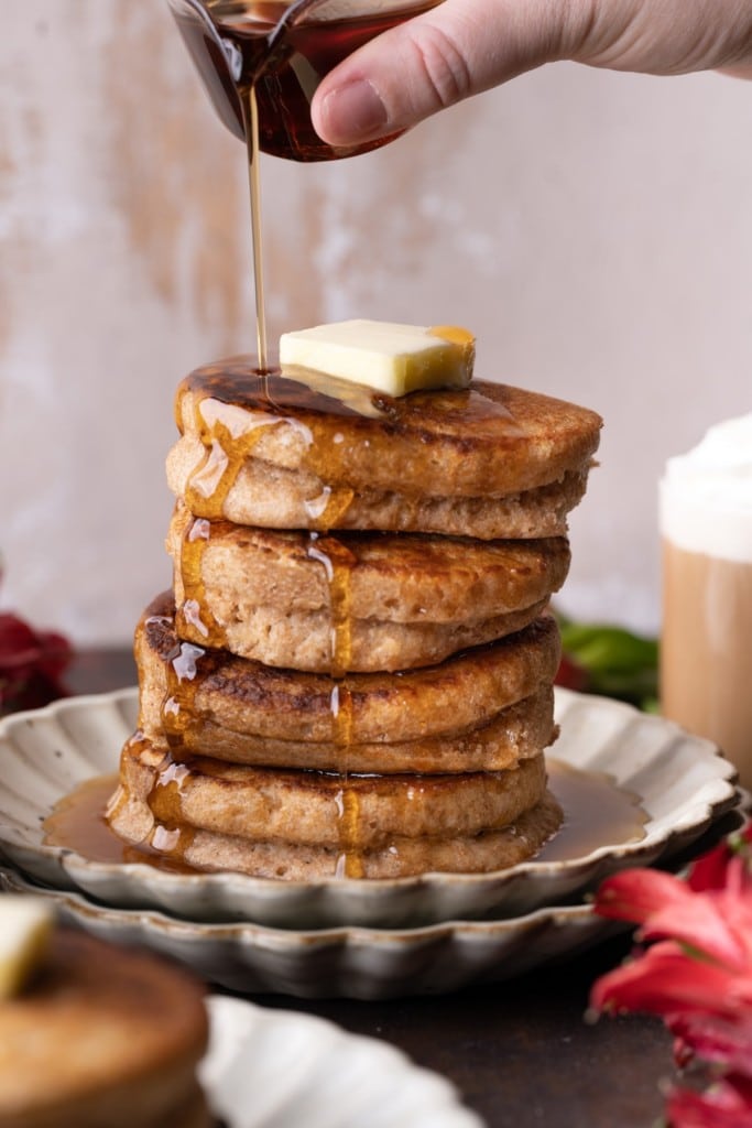 Maple syrup dripping down stack of light and airy Whole Wheat Pancakes