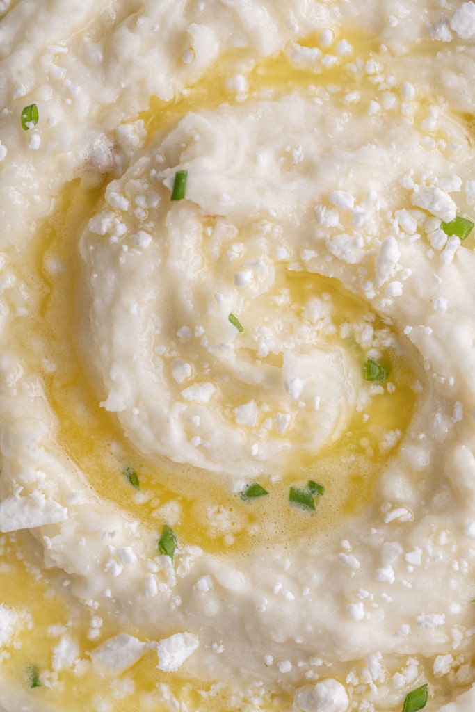 Close up of swirl created in Roasted Garlic and Feta Mashed Potatoes accentuated by melted butter