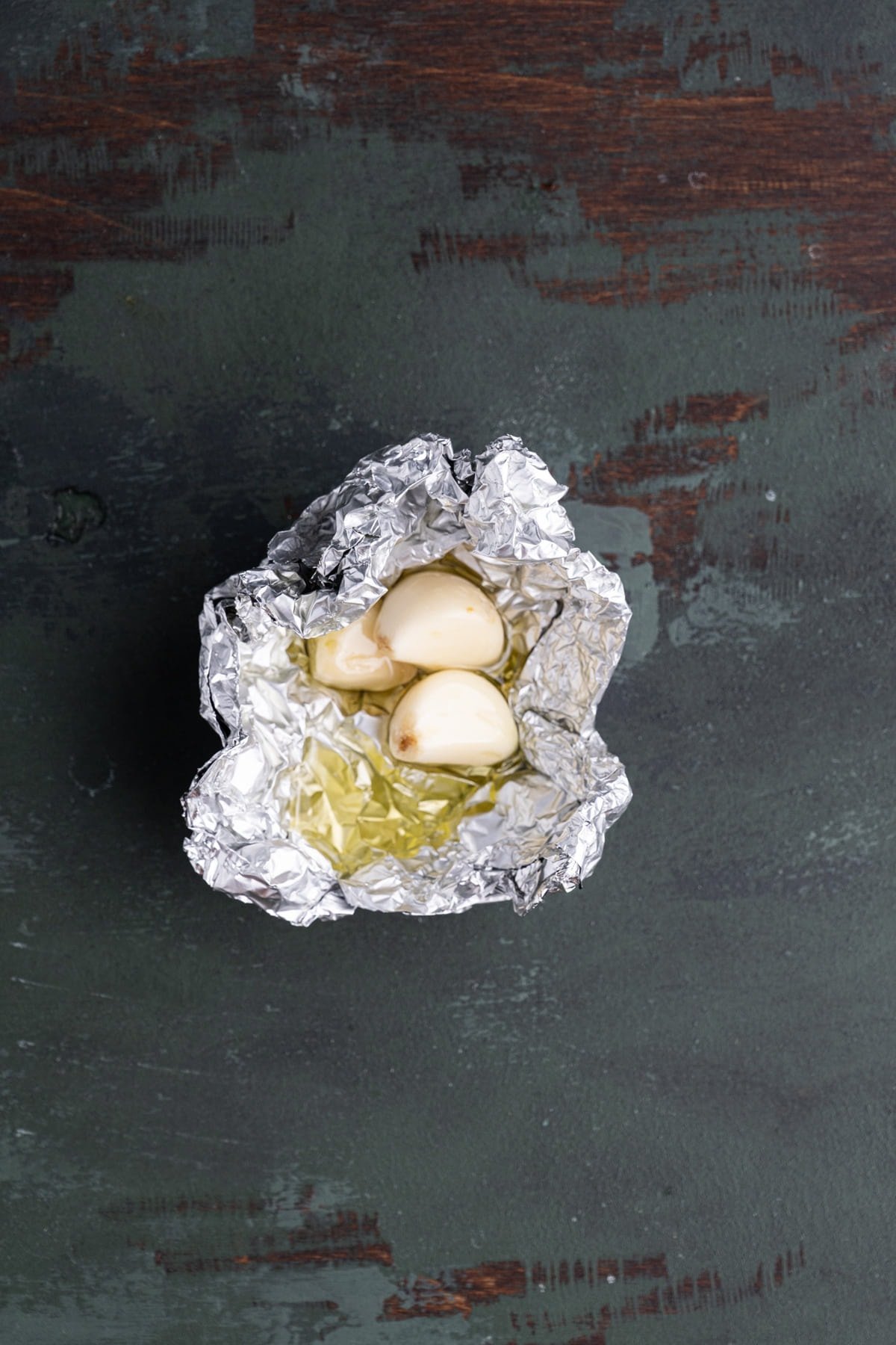 3 cloves of peeled garlic in aluminum foil covered with olive oil