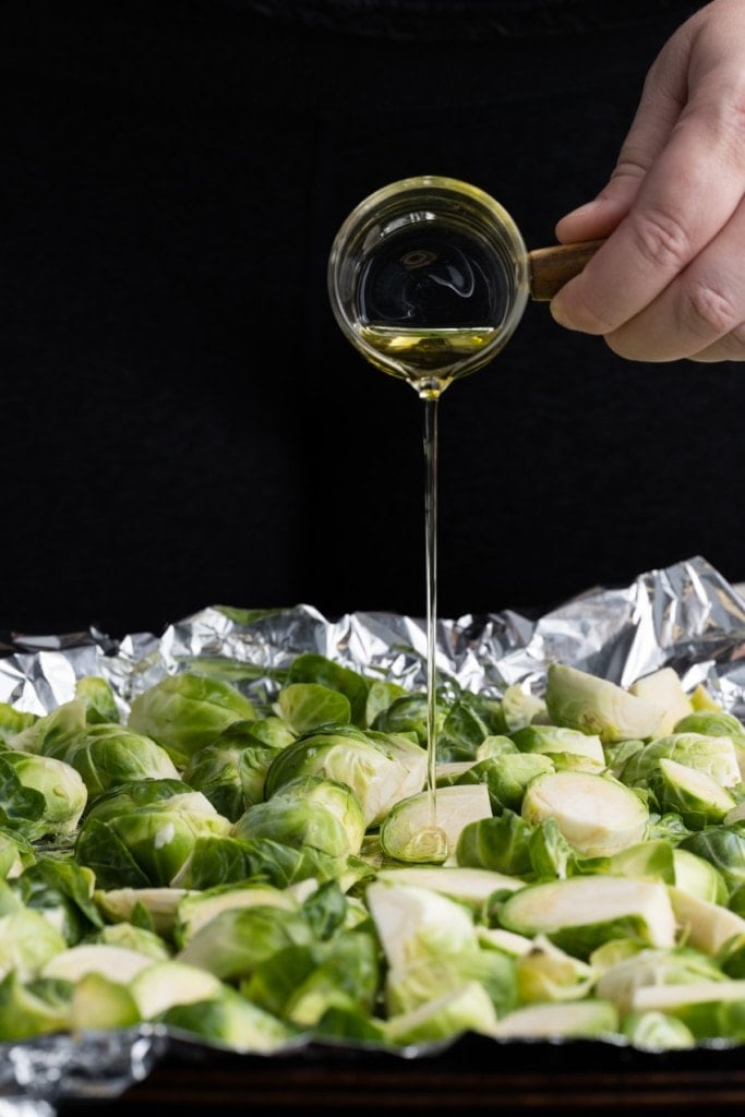 adding olive oil to brussels sprouts to roast them