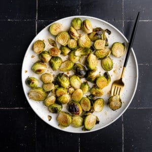 white plate with crispy sweet and salty brussels sprouts
