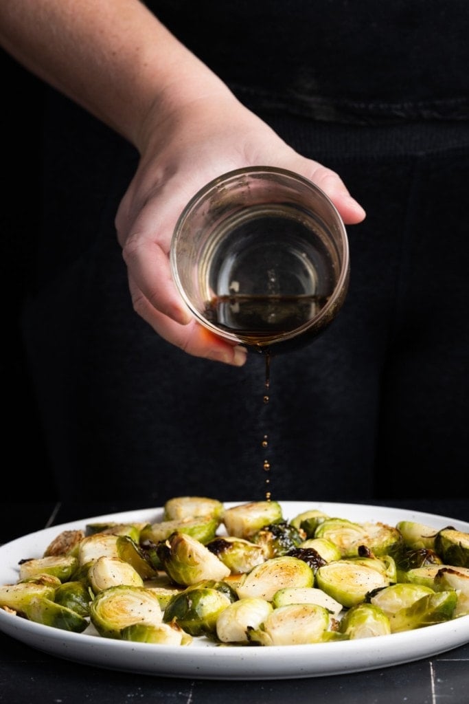 pouring 3 ingredient sauce over brussels sprouts