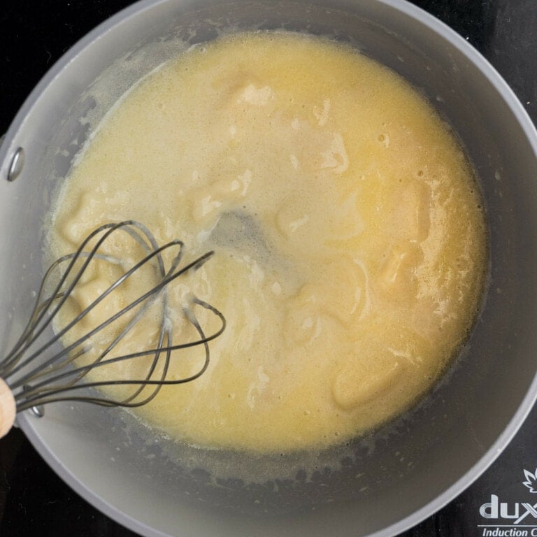Whisking Tex Mex Queso Blanco over low heat