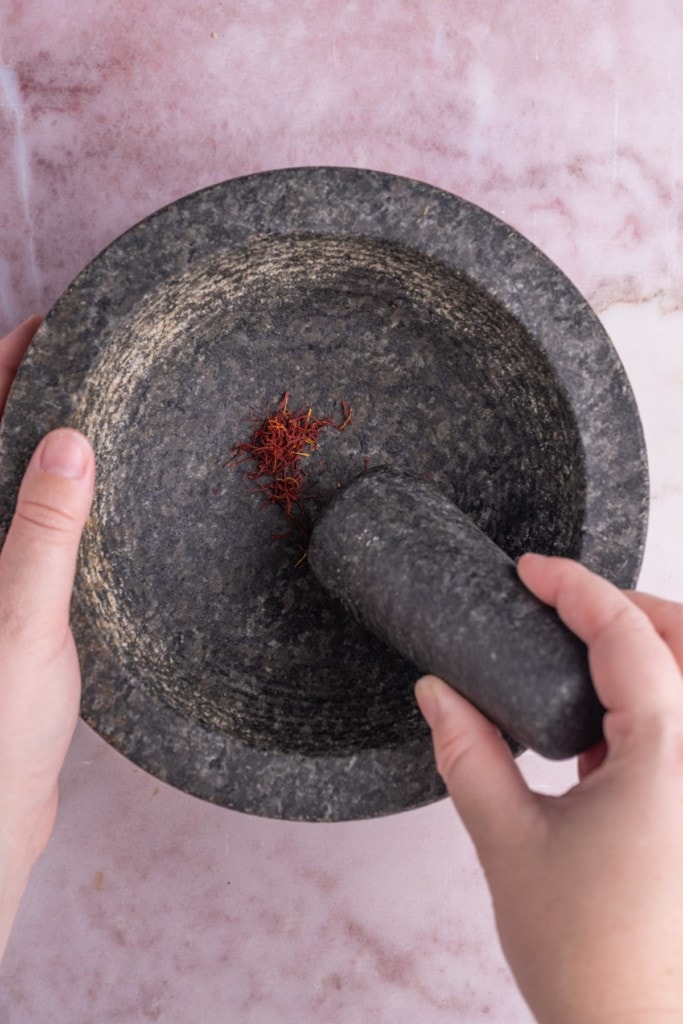Using a mortar and pestle to grind saffron
