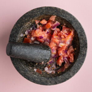 Smashed tomato and onion in mortar