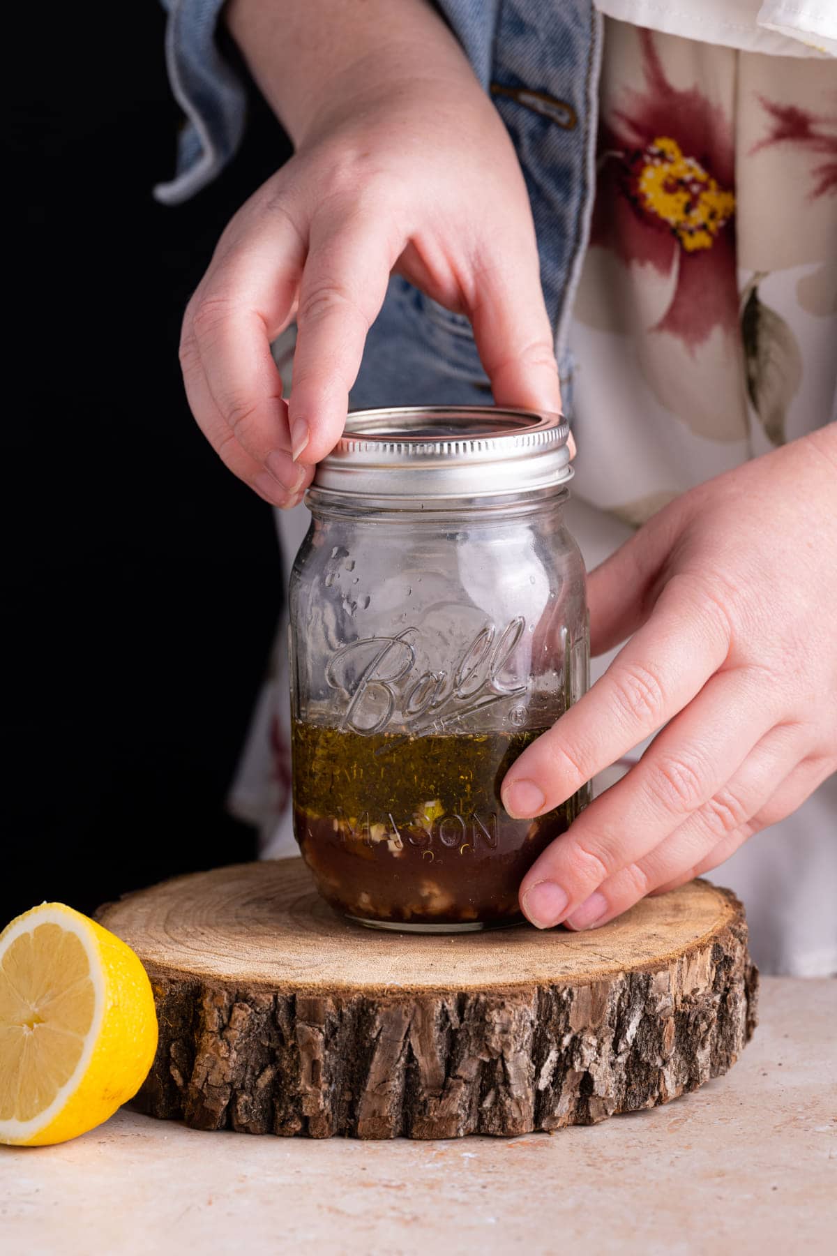 Fastening lid on a mason jar to shake vinaigrette to emulsify it