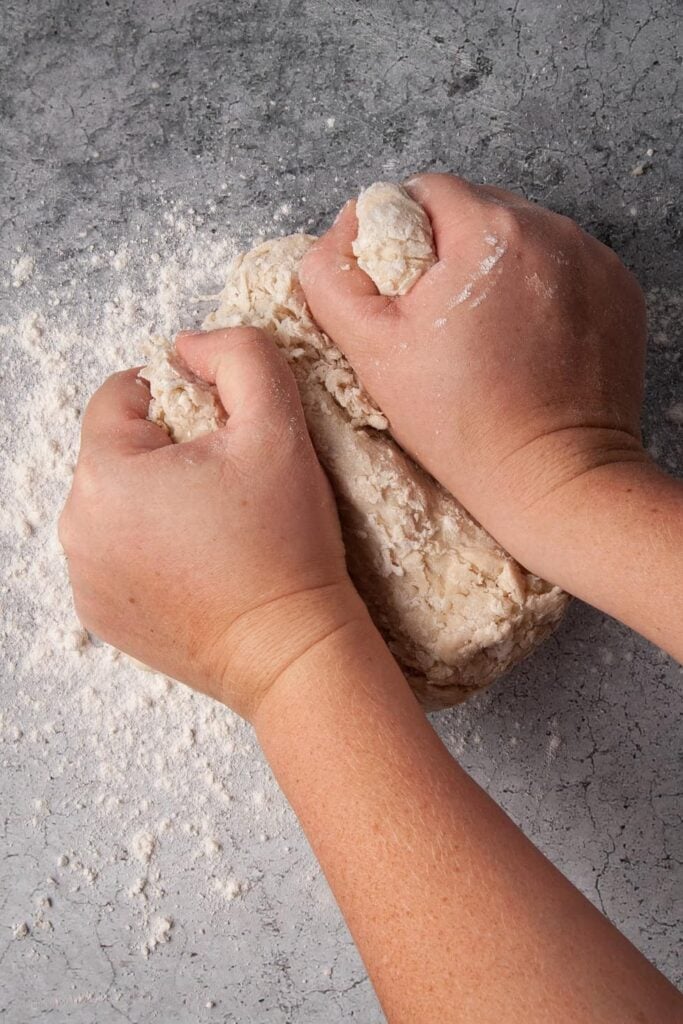 Kneading tortilla dough on a floured surface.