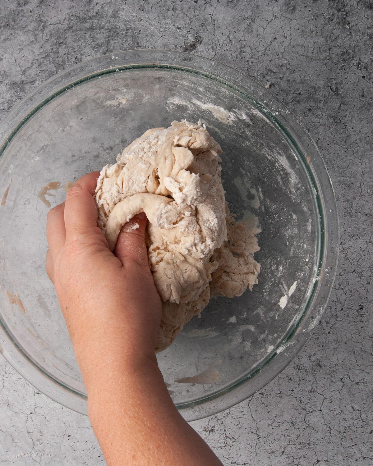 using hands to mix dough together