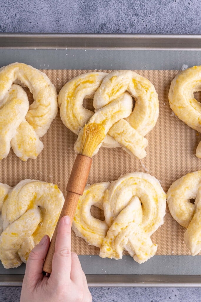 Brushing egg wash onto pretzels