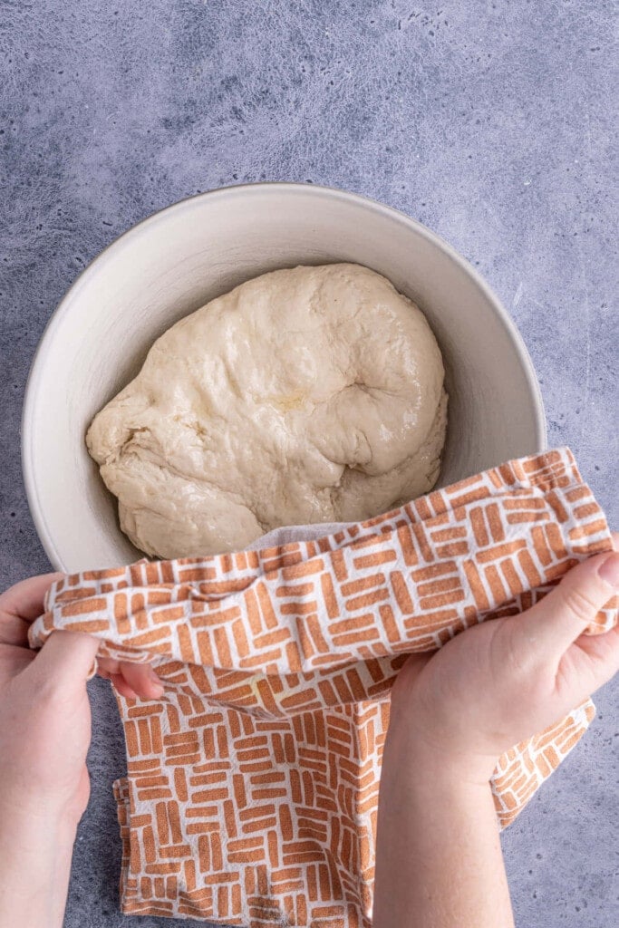 Covering pretzel dough and setting it aside to rise