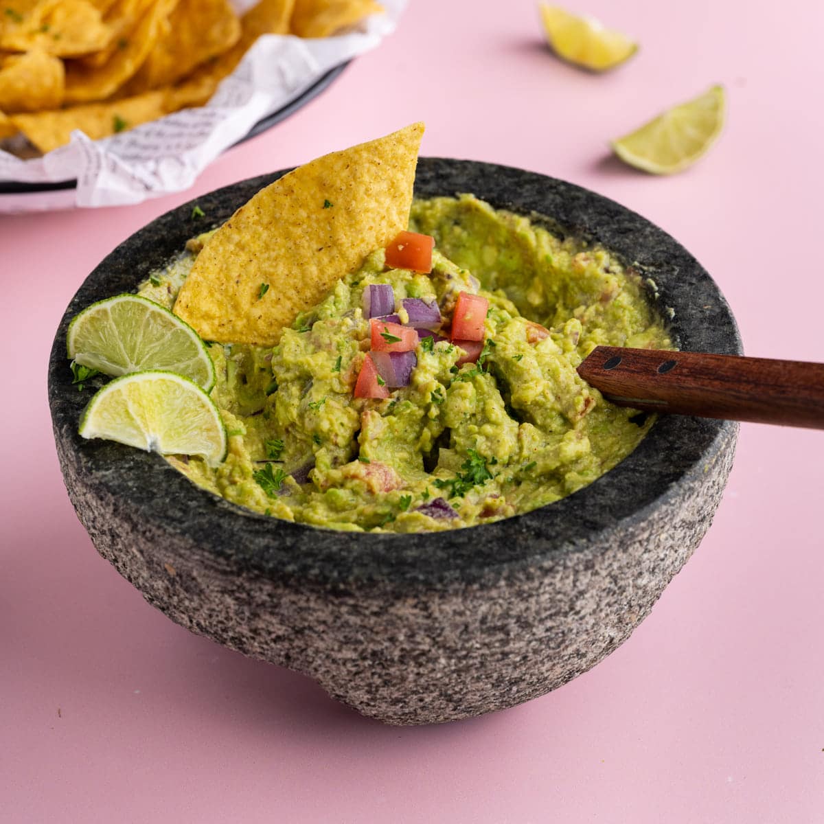 Homemade Tableside Guacamole in a mortar with a tortilla chip sticking out