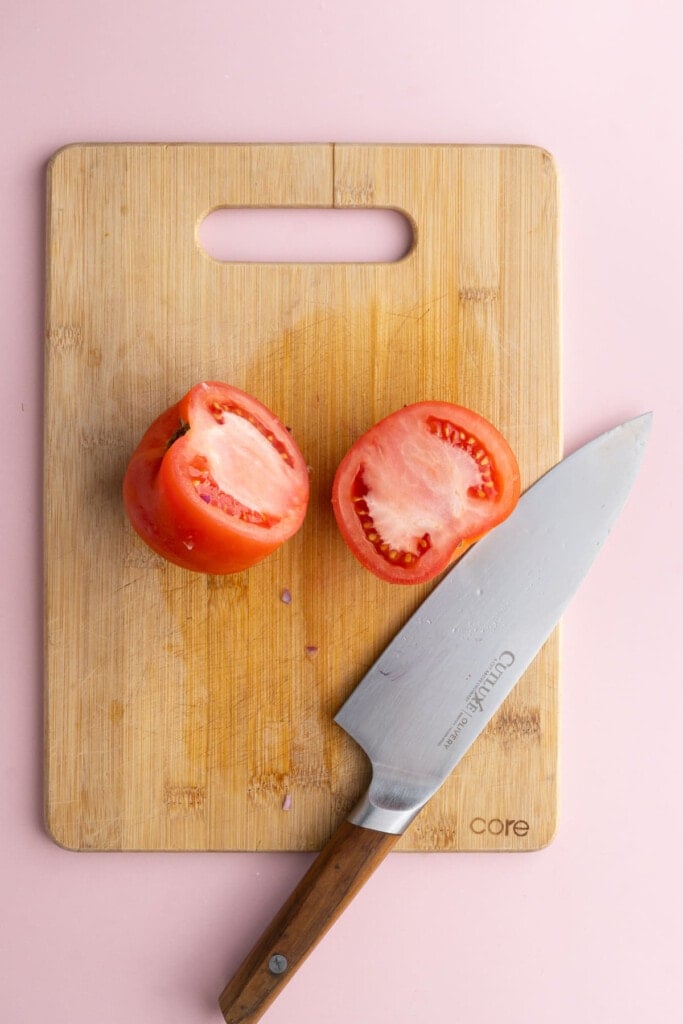 Slicing tomato in half to lay it flat
