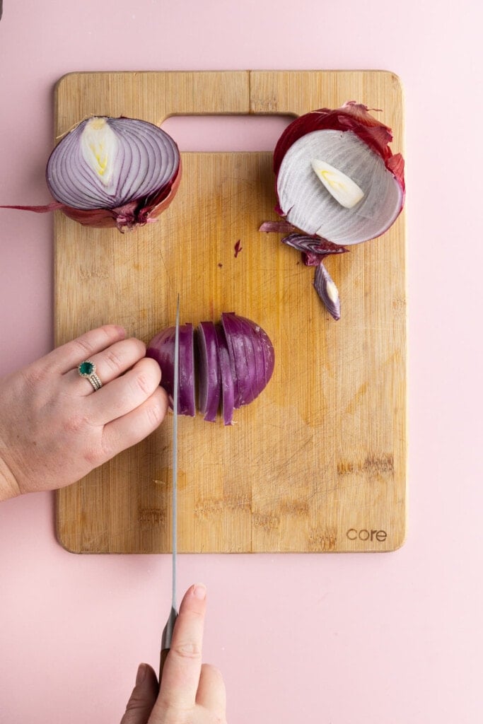 Slicing red onion into thin strips