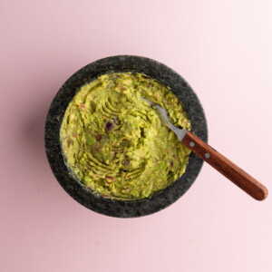 Using fork to mix lime juice and seasonings into guacamole