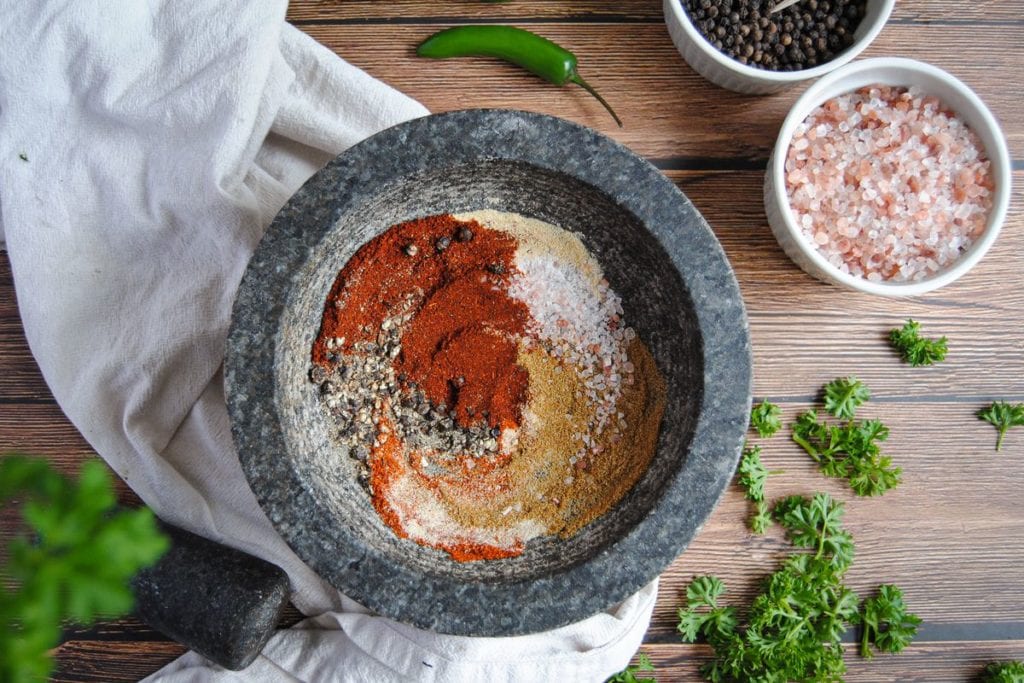 Overhead Image of chili and taco seasoning with parsley peaking through the side of the frame