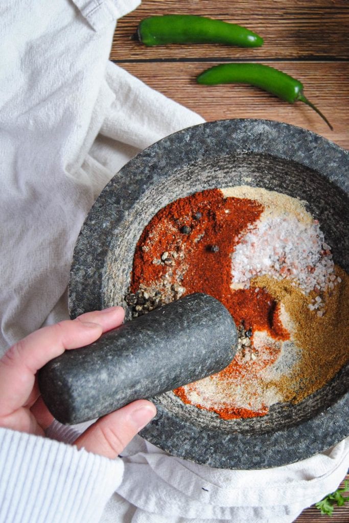 Using pestle to mix up chili and taco seasoning