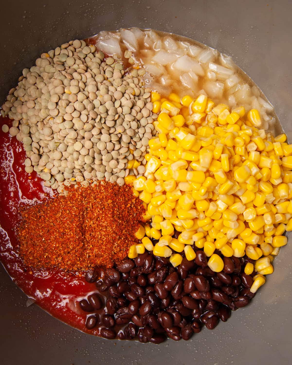 adding all vegan chili ingredients to the pot to cook