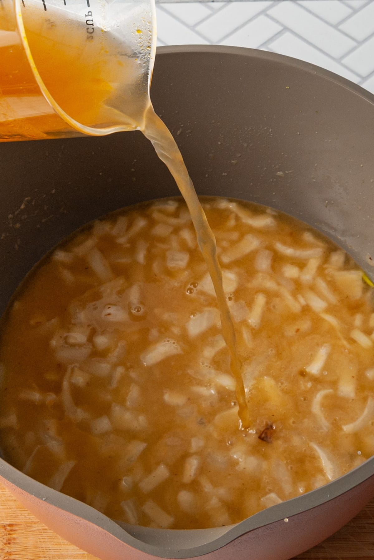 adding vegetable broth to onion roux