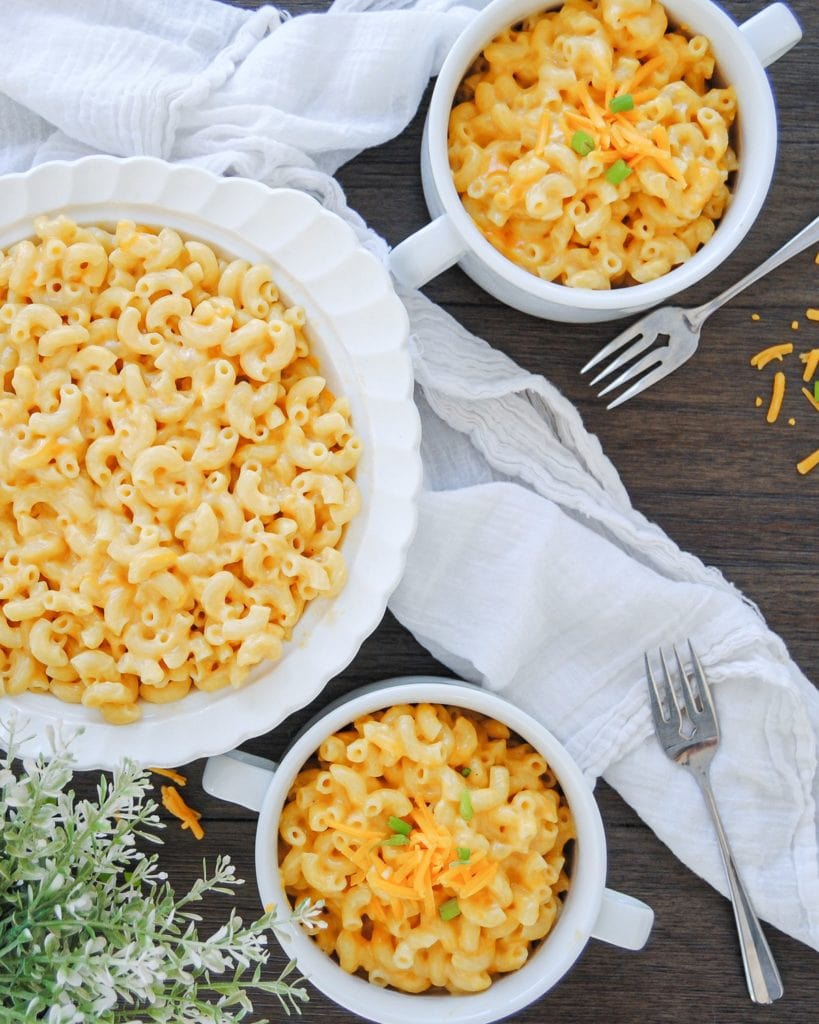 Picture of Serving bowl of mac -n-cheese surrounded by two little servings of mac-n-cheese and forks