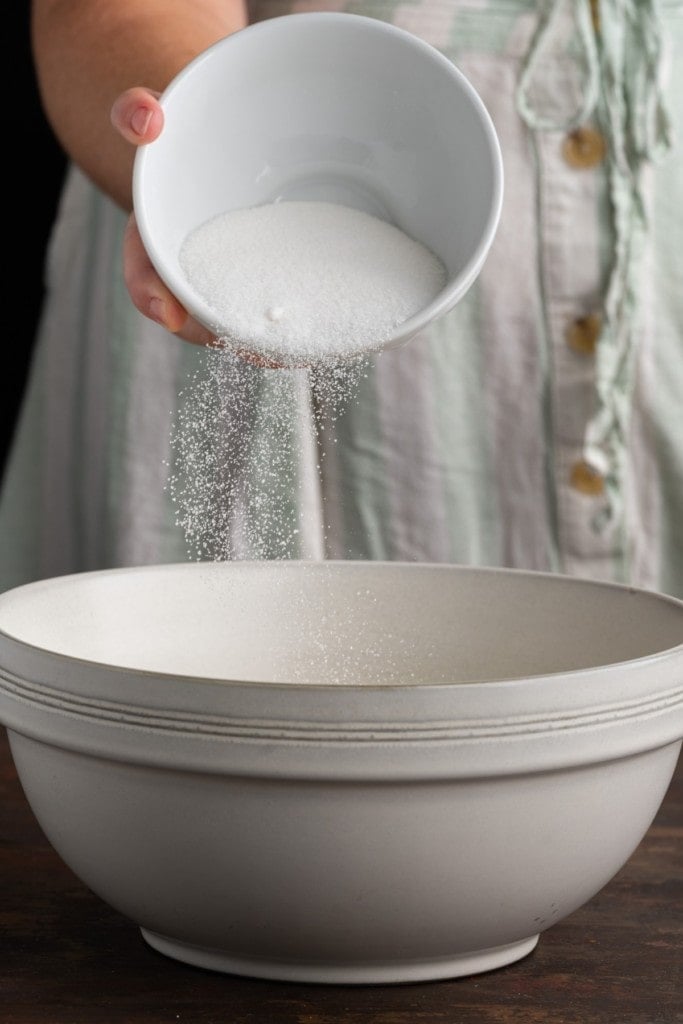 adding granulated sugar to softened butter and brown sugar to cream together