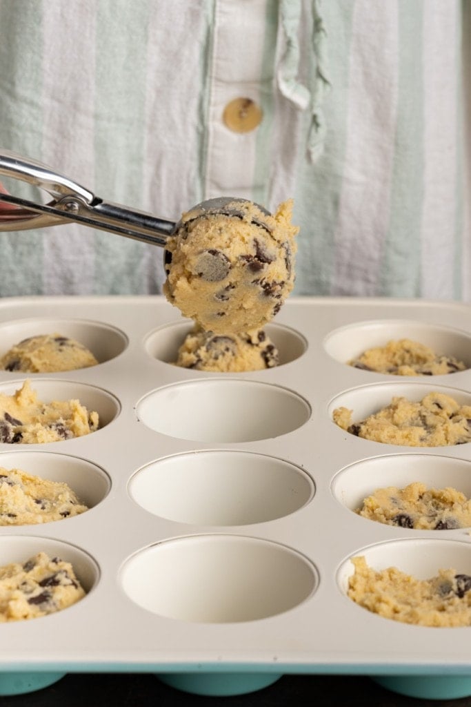 adding cookie dough to muffin tins