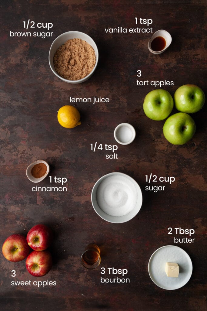 Everything you need to make bourbon apple pie filling including brown sugar, vanilla extract, lemon juice, tart and sweet apples, salt, cinnamon, granulated sugar, bourbon, and butter.