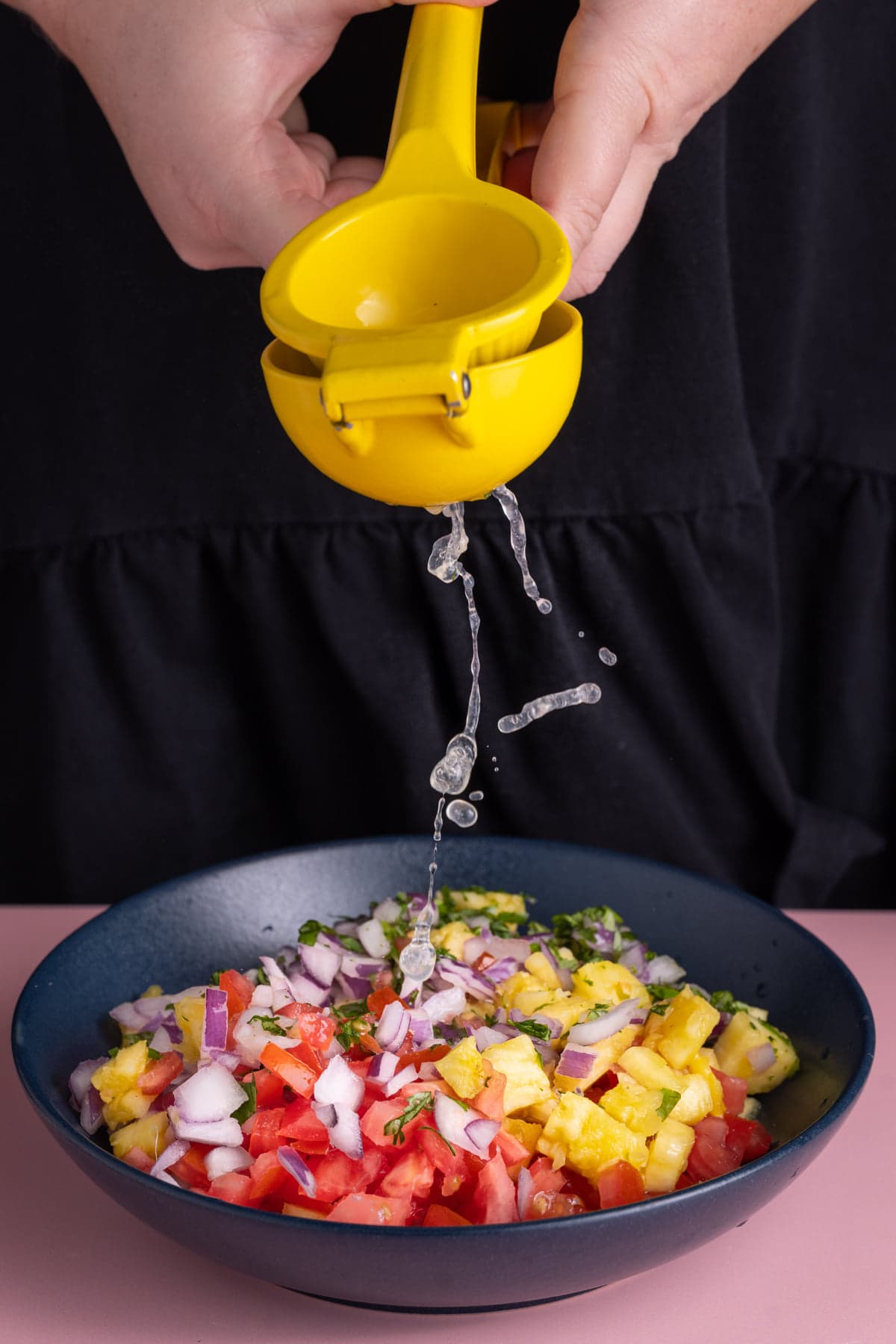 Squeezing fresh lime juice over Pineapple Pico de Gallo