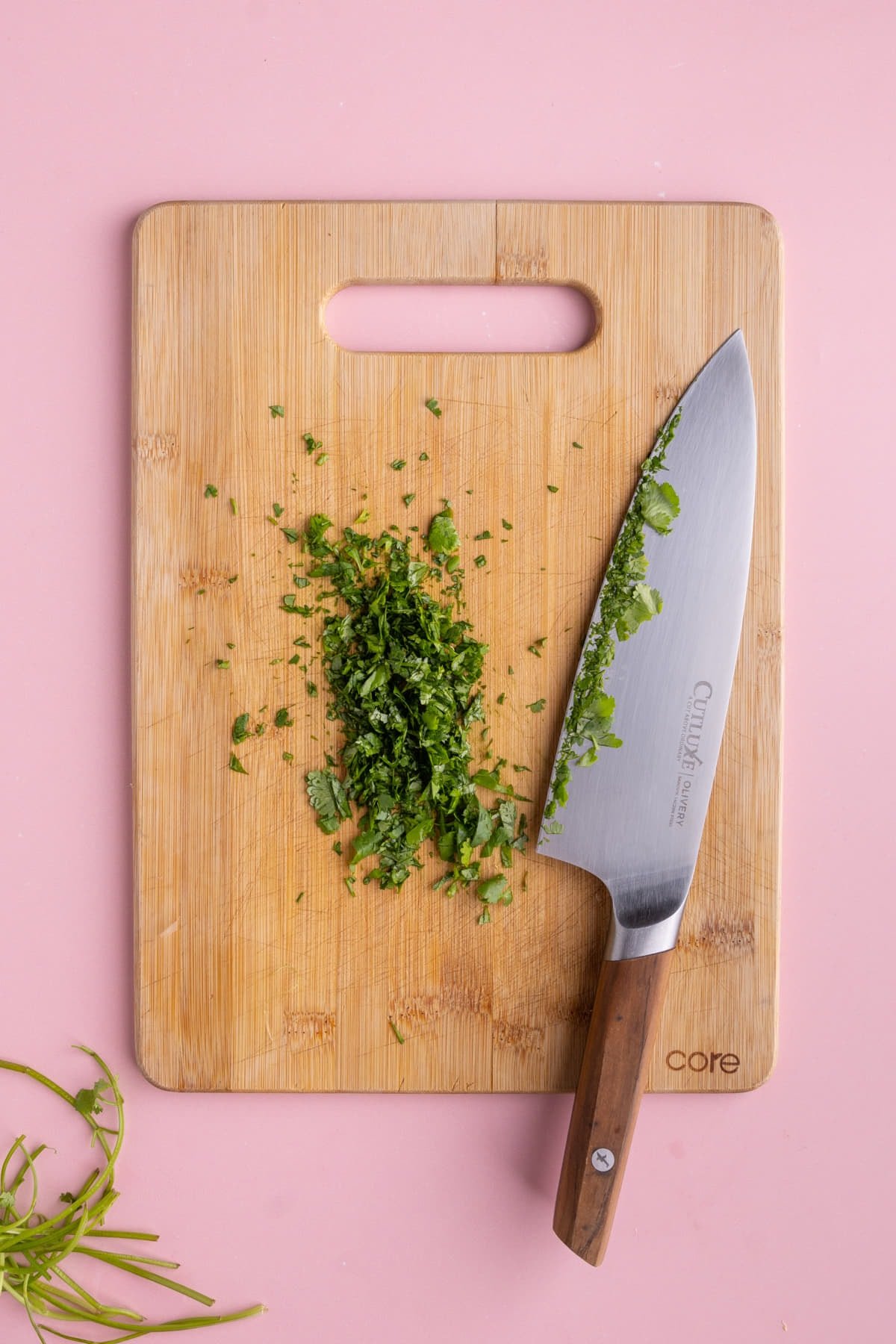 Chopped cilantro on a cutting board with sharp knife