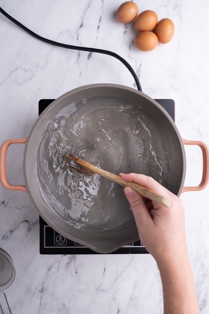Rapidly stirring boiled water in a pot to make a whirlpool