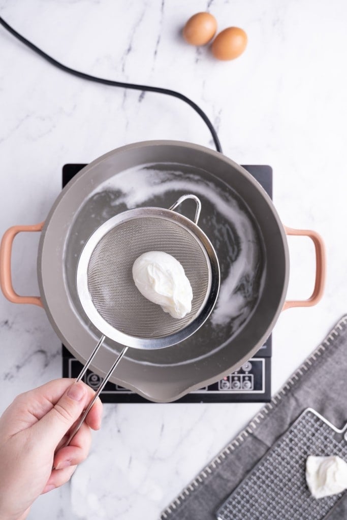 Using a sieve to remove perfectly poached egg from hot water