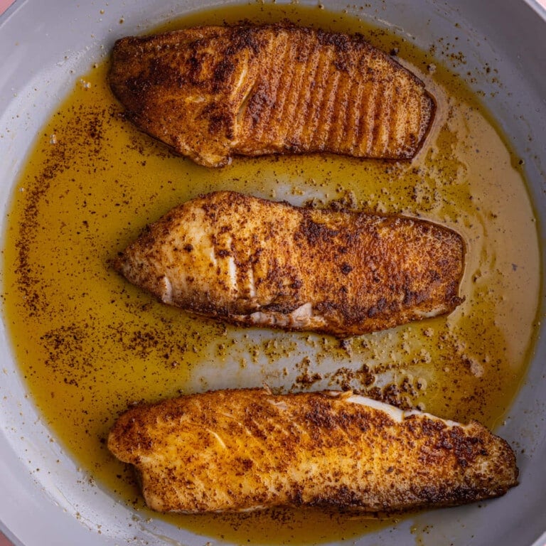 Cooking tilapia in coconut oil on the second side after flipping