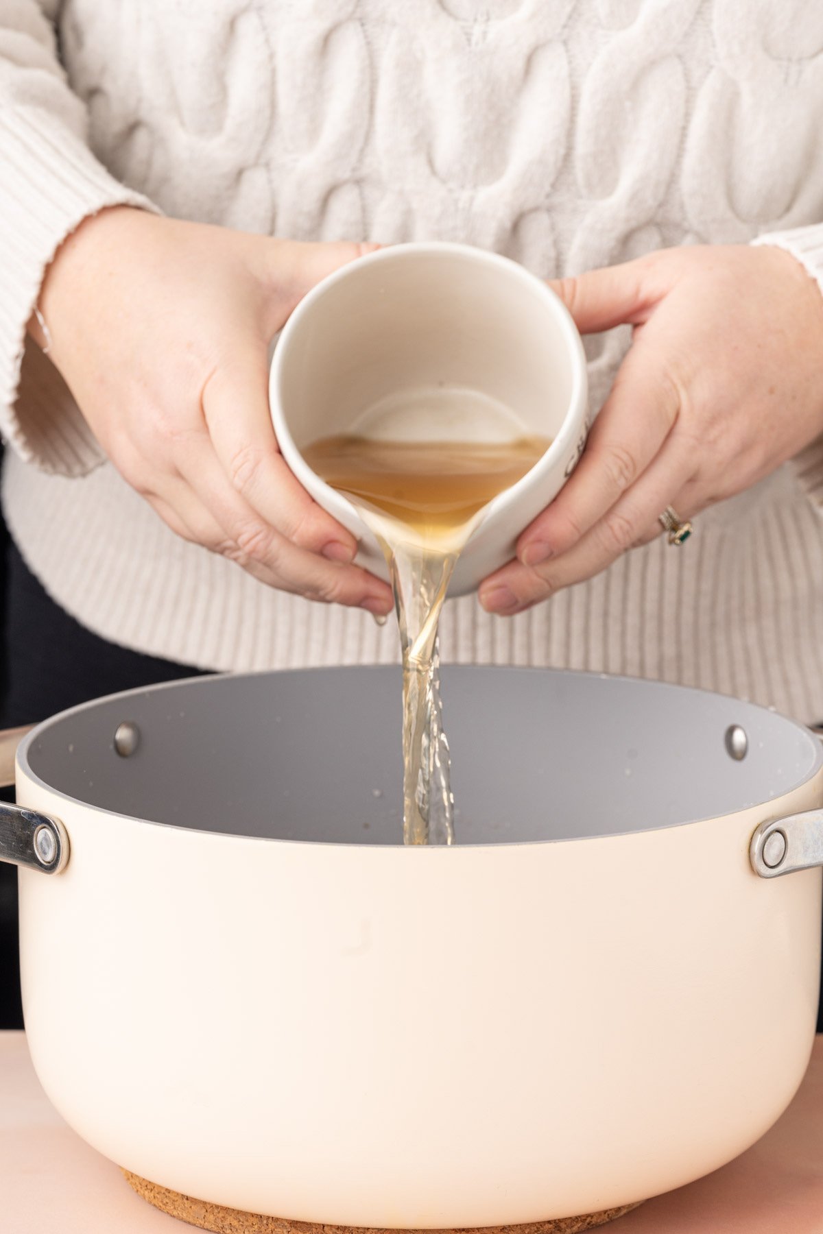 Adding vegetable broth to a large pot to make a flavorful vegetarian broth for ramen. 