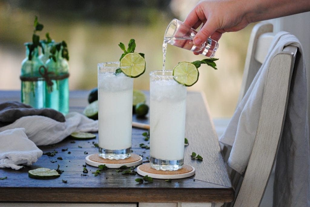 pouring more rum into a ginger beer cocktail