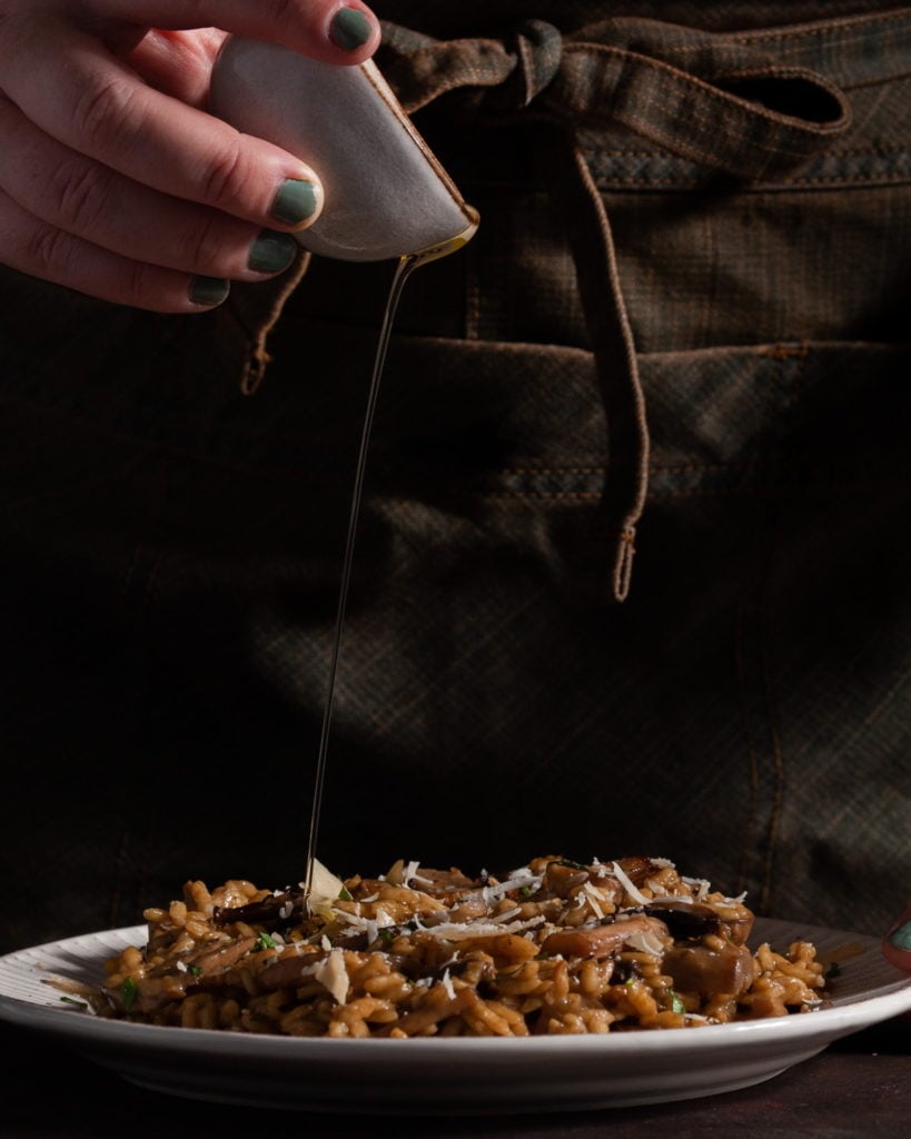 adding truffle oil to plated risotto