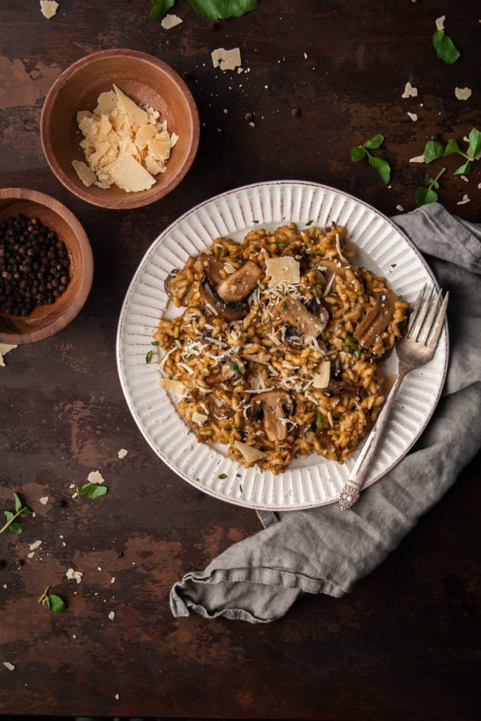 risotto with truffle oil and mushrooms on a plate with a fork