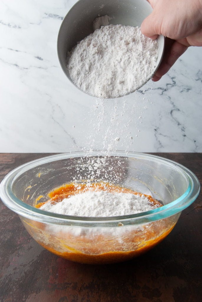 Adding flour to pumpkin based batter.