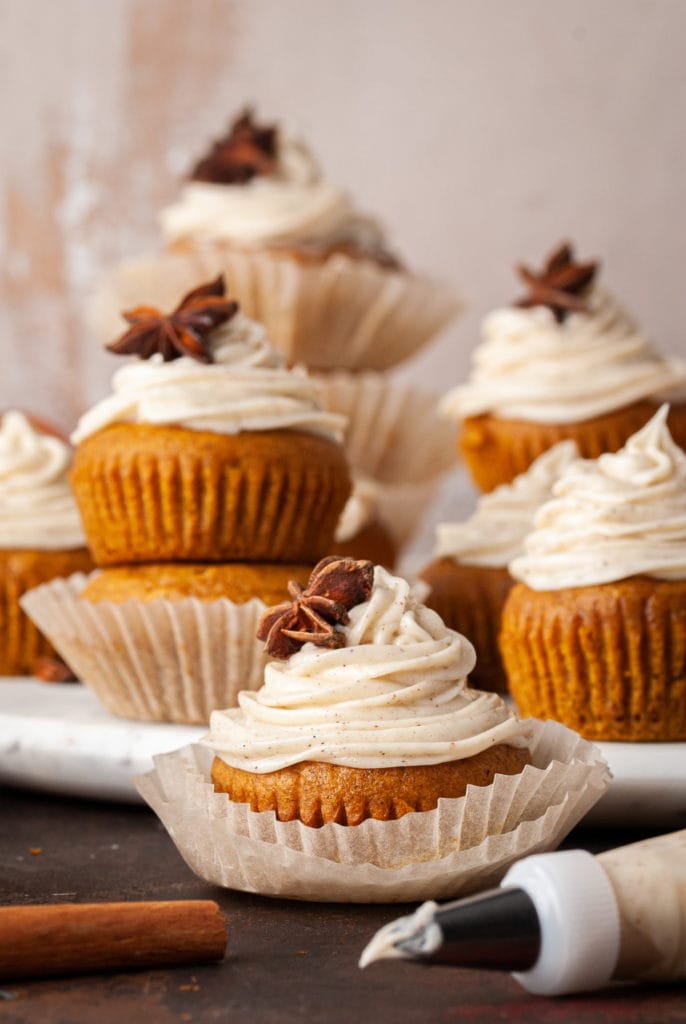 pumpkin muffins with spiced cream cheese frosting garnished with star anise