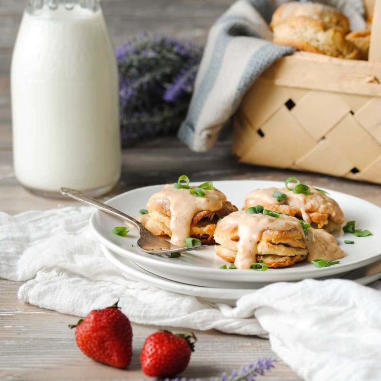 milk jug, basket of biscuits, and a plate full of vegetarian biscuits and gravy