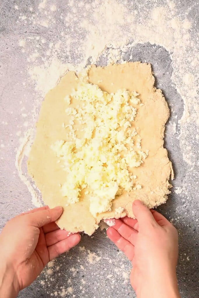 Folding a layer of butter into biscuit dough.