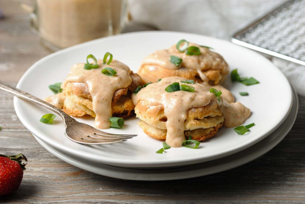 vegetarian gracy dripping off of biscuits with scallions on top