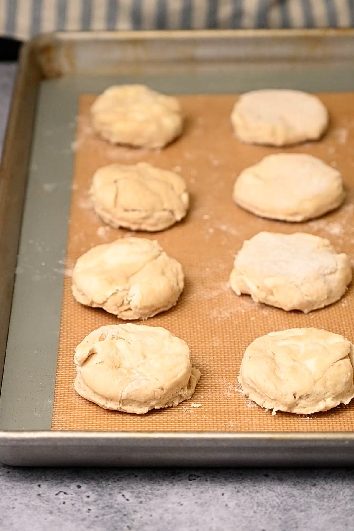 Biscuits lined up on a baking sheet ready for the oven.